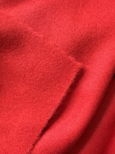 closeup of red fabric textured with black stitching on the bottom right corner