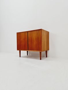 a small wooden cabinet sitting on top of a white floor