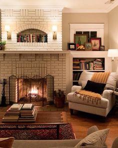 a living room filled with furniture and a fire place next to a book shelf full of books