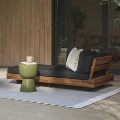 a living room with a couch, coffee table and potted plant on the floor