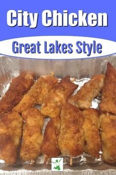 some chicken sticks are sitting in a tin foil container with the words city chicken great lakes style