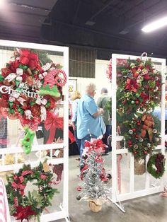 people are looking at christmas wreaths on display