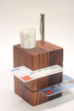 a wooden holder with two credit cards and a coffee cup on top, sitting next to each other