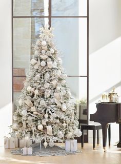 a white christmas tree with presents under it