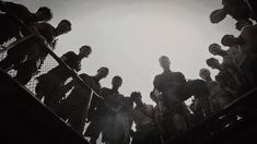 a group of people standing on top of a metal stair case next to each other