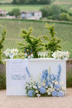 an outdoor bar set up with flowers and wine glasses