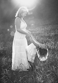 a mother and her daughter playing in the grass at sunset, black and white photograph