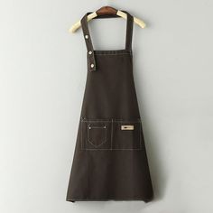 a brown apron hanging on a white wall