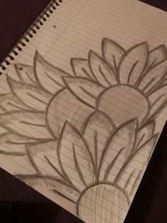 a drawing of a flower is shown on a piece of paper with graphite pencils