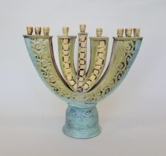 a ceramic menorah with five candles in it