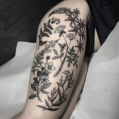 a woman's leg with flowers and leaves on it