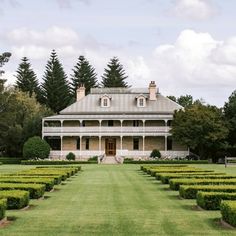 a large house surrounded by hedges and trees