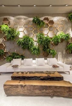 a living room filled with furniture and lots of greenery on the wall behind it