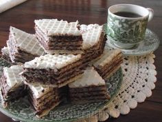 a stack of waffles sitting on top of a plate next to a cup of coffee