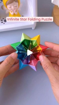 someone is holding an origami star in front of the camera and another person's hand