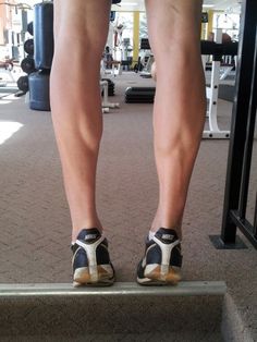 the legs of a person standing on a step in a gym