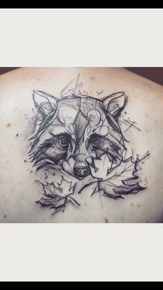 a tattoo on the back of a woman's shoulder with a wolf head and leaves