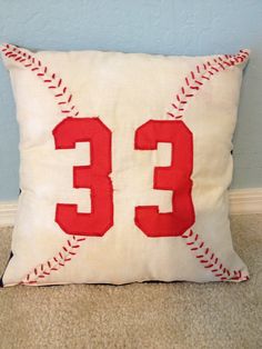 a baseball pillow with the number 33 embroidered on it's side, sitting in front of a blue wall