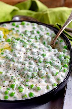 a bowl filled with peas and cream on top of a table