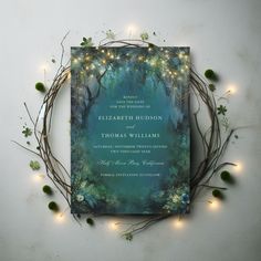 the wedding card is surrounded by greenery and fairy lights