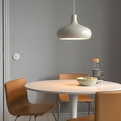 a white table with four chairs around it and a bowl of food on the table