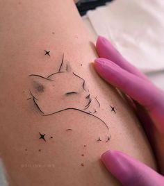 a woman's arm with a cat tattoo on the left side of her body