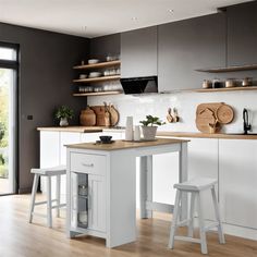 a kitchen with white cabinets and wooden counter tops next to a sliding glass door that leads to an outside patio