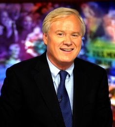 a man in a suit and tie is smiling for the camera while wearing a blue tie