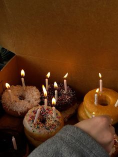 a box filled with donuts covered in candles