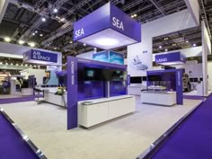 an exhibit booth with purple and white accents on the walls, flooring and ceiling