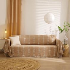 a living room with a couch, rug and lamp on the side table in front of it