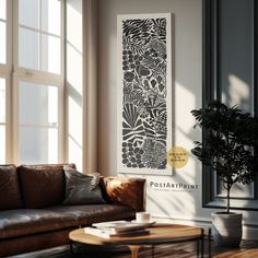 a living room with a couch, coffee table and potted plant on the wall