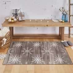 a wooden table topped with a gray rug covered in snowflakes and other decorations