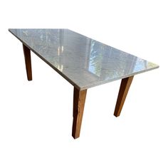 a table that is made out of wood and glass with a marble top on it