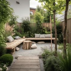 a wooden bench sitting in the middle of a garden next to a tree and shrubbery