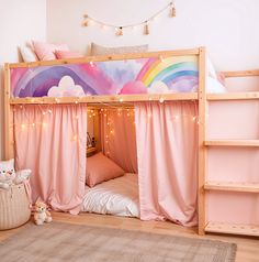 a child's bed with pink curtains and fairy lights