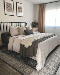 a bedroom with a bed, rug and pictures on the wall