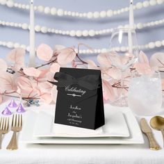 a black and white wedding table setting with silverware, napkins and place settings