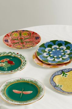 five plates with designs on them sitting on a table top, all decorated in different colors