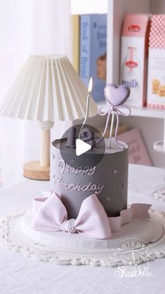 a birthday cake sitting on top of a table next to a lamp and other items