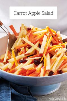 carrot apple salad with cranberries in a blue bowl on top of a table