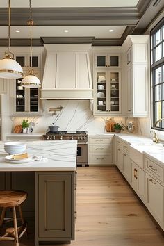 a large kitchen with white cabinets and wooden floors