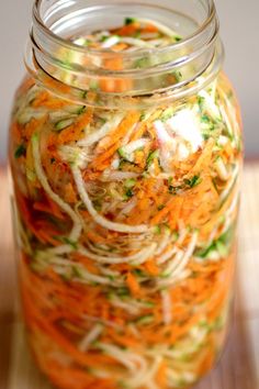 a glass jar filled with shredded carrots and other vegetables