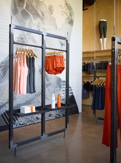 an open clothing store with clothes hanging on racks