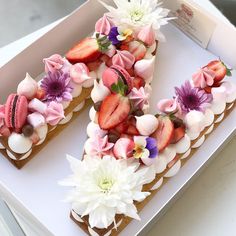 there is a decorated letter made out of cookies and strawberries in the shape of flowers