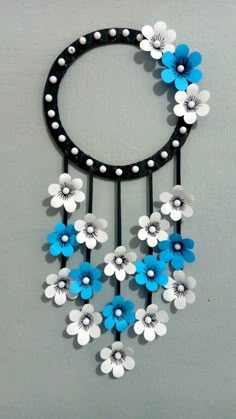 a black and white circular wall hanging with blue, white and gray flowers on it