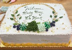 a cake with white frosting and green leaves on it that says welcome baby boy to be mine