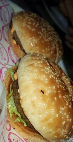 two hamburgers sitting on top of a paper plate