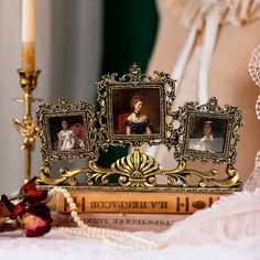 an antique photo frame with three pictures on it next to a candle and some pearls