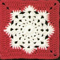 a red and white crocheted square with snowflakes on it is shown